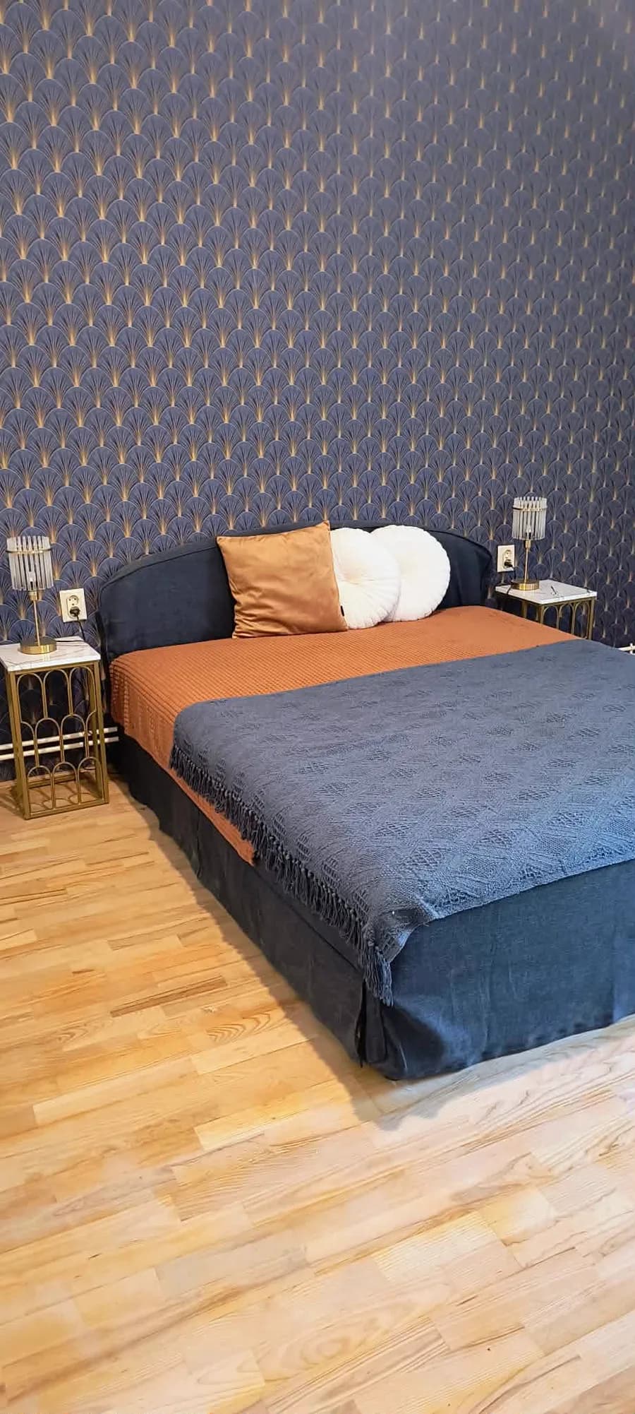 Hálószoba – franciaágy legyezőmintás Art Deco tapéta előtt, arany éjjeliszekrényekkel